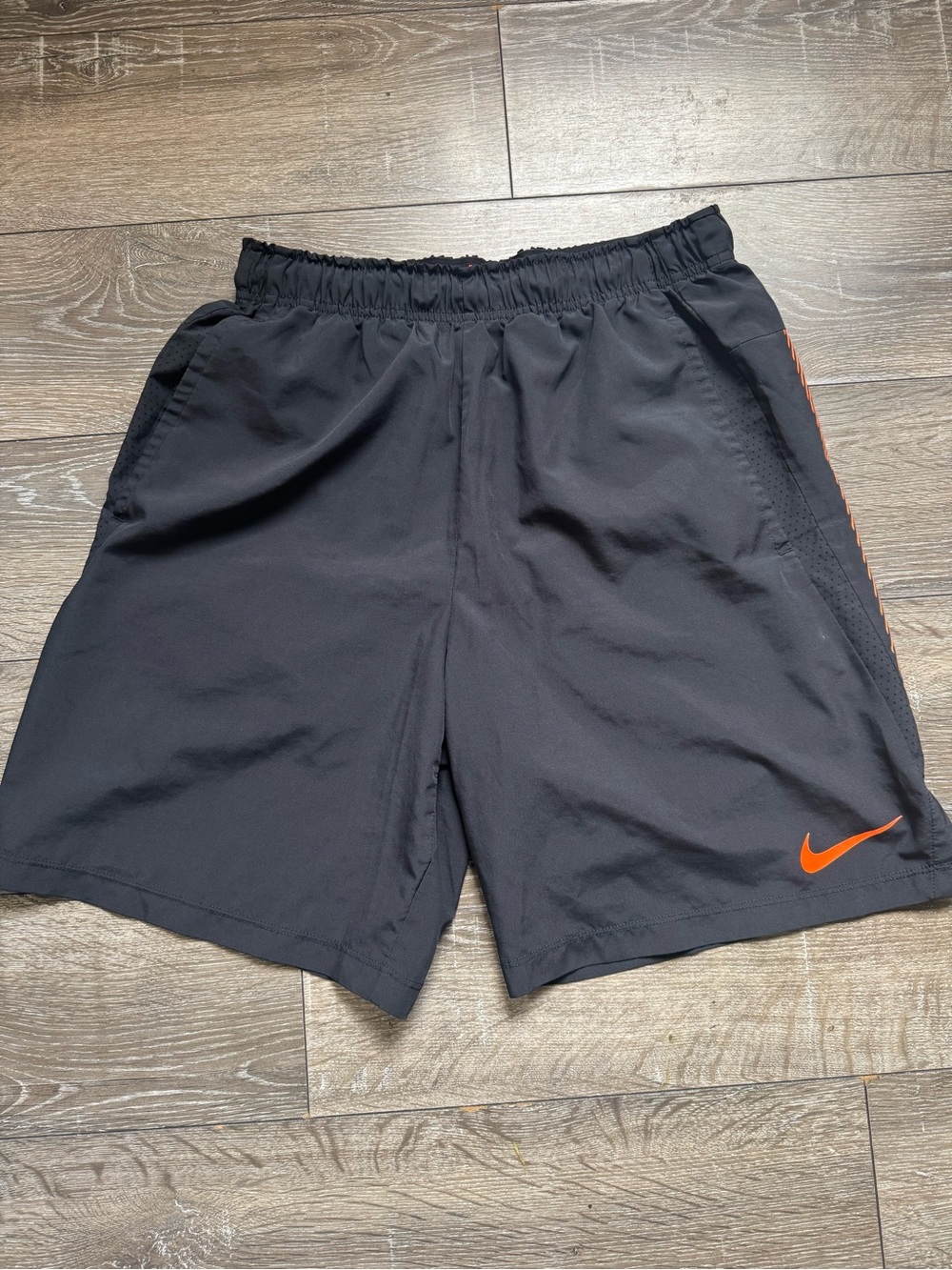 Nike Men's Black Athletic Shorts with Orange Swoosh Accent